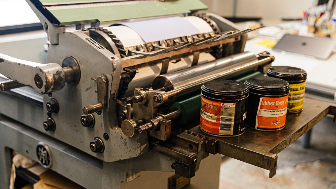 Printing press with cans of ink in a workshop